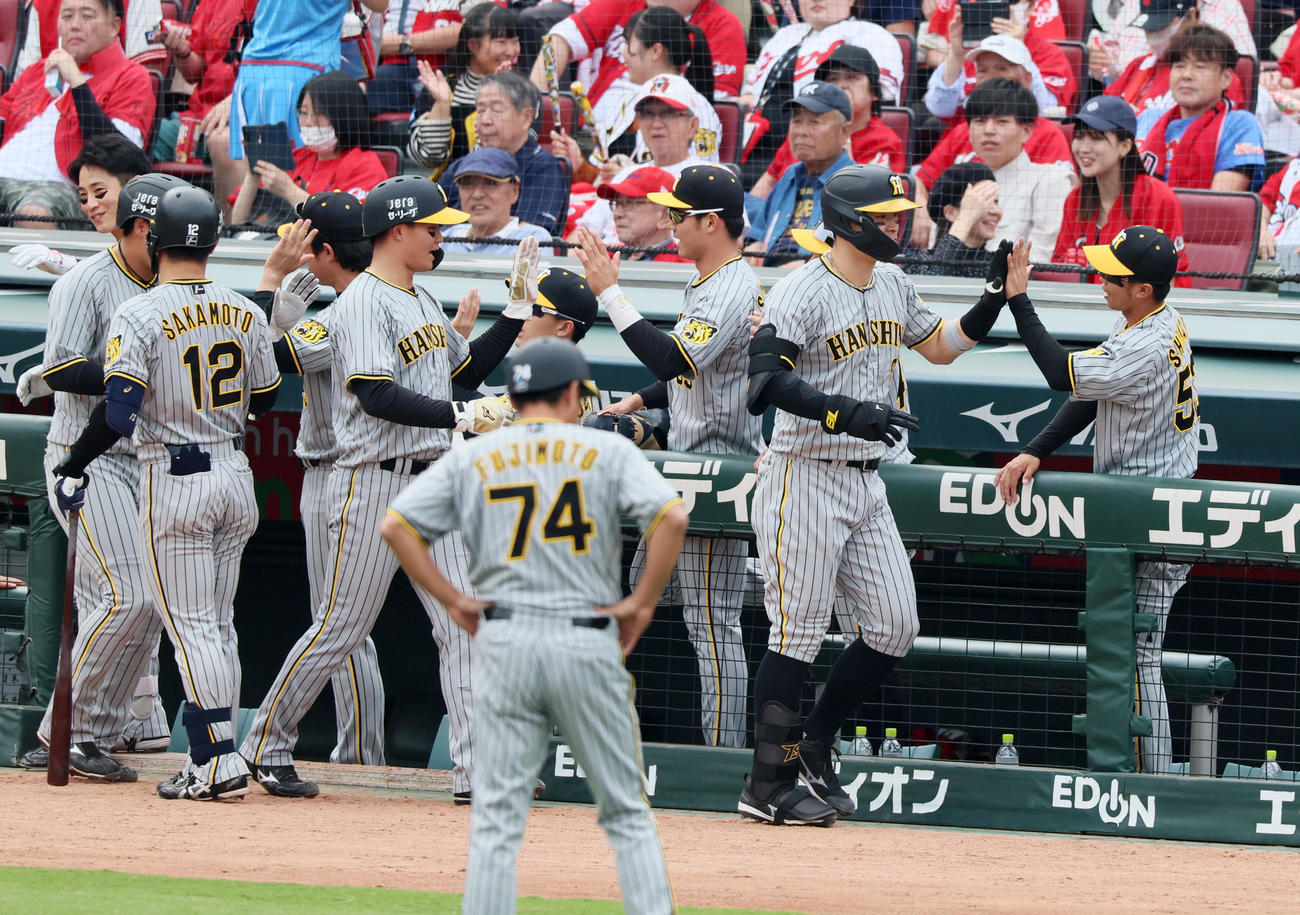 広島対阪神　5回表阪神無死一、二塁、右越え3点本塁打を放った佐藤輝はベンチのナインとタッチ（撮影・加藤哉）