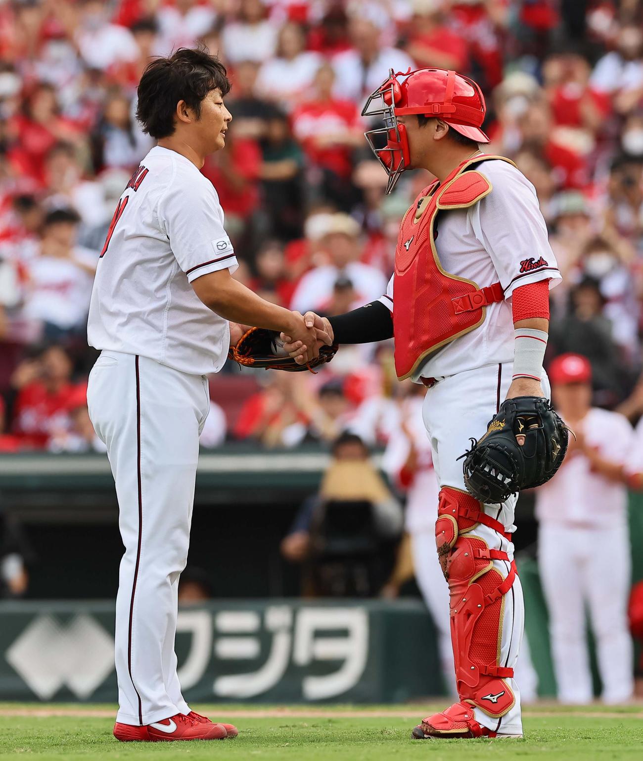 広島対阪神　登板を終えた一岡（左）は会沢とあくしゅを交わす（撮影・上田博志）