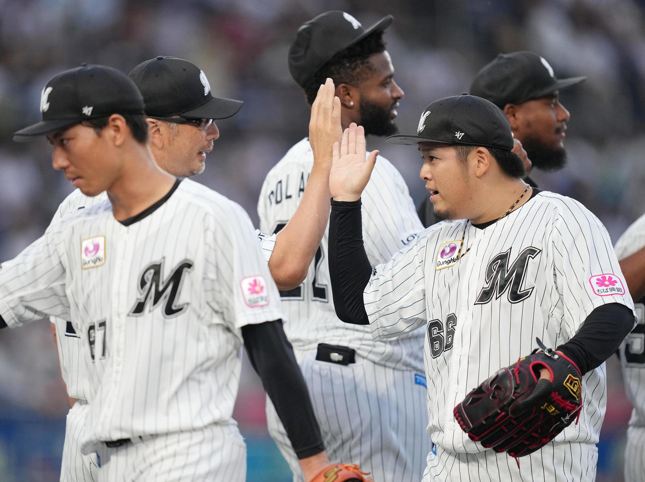 ロッテ対西武　西武に勝利し、吉井監督（左奥）とタッチを交わすロッテ沢田（撮影・鈴木みどり）