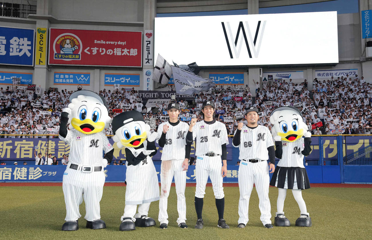 ロッテ対西武　西武に勝利しファンをバックに記念撮影するロッテの選手たち。左から和田、岡、沢田（撮影・鈴木みどり）