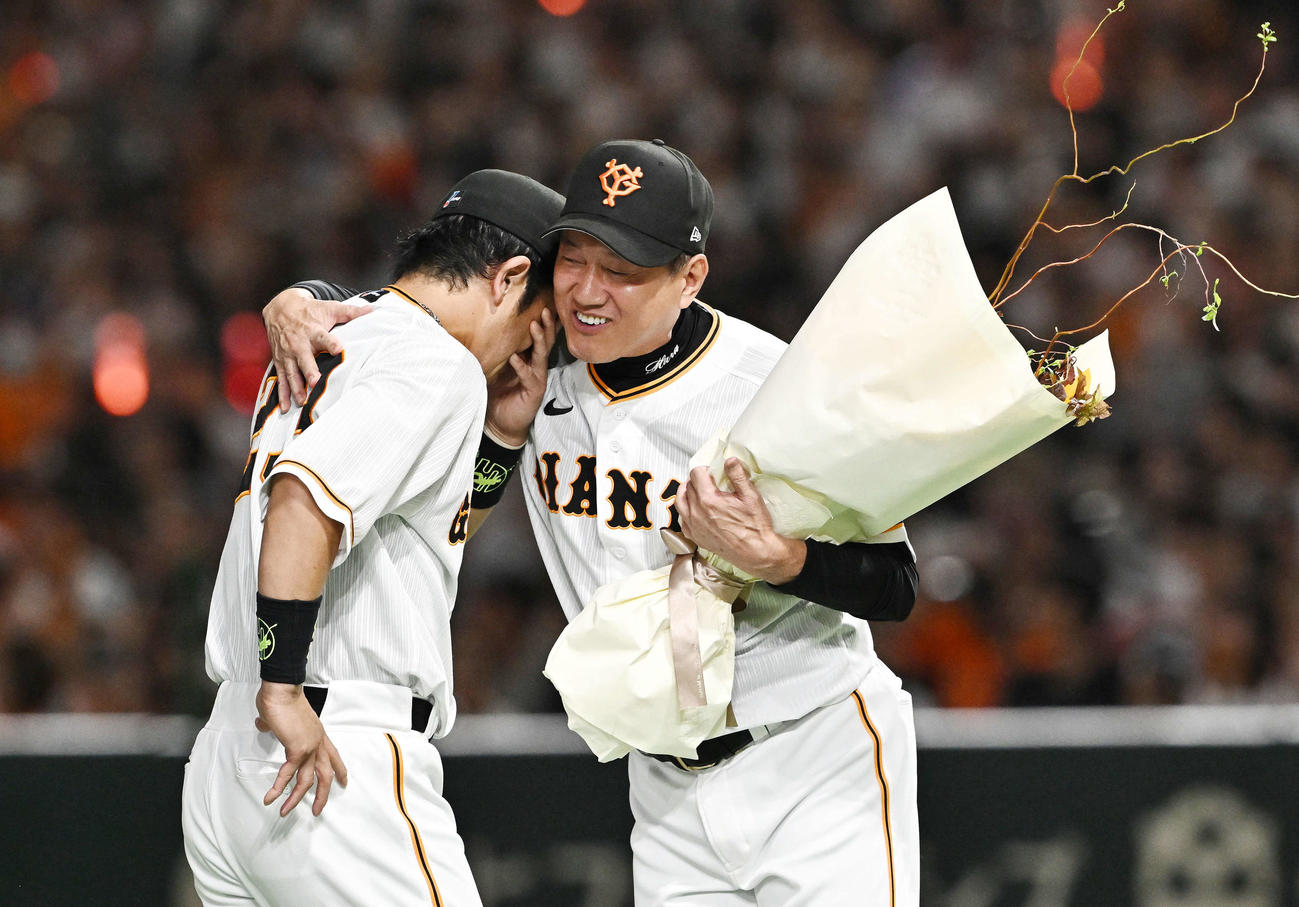 巨人対ヤクルト　巨人松田（左）の引退セレモニーで花束を渡す前に抱き寄せる原監督（撮影・滝沢徹郎）