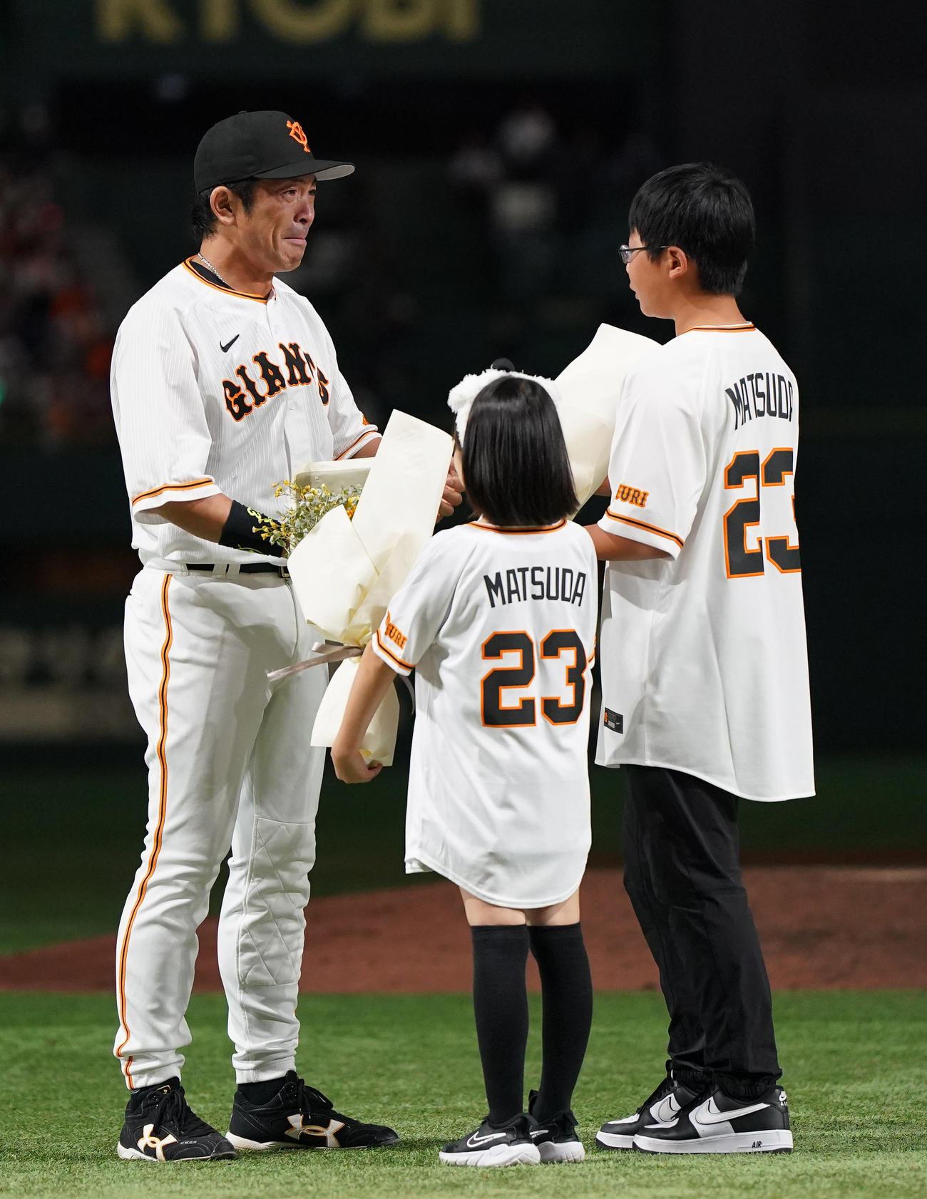 引退セレモニーで長男一冴君（右）、長女麗衣ちゃん（中央）から花束を受け取り、涙を流す松田（撮影・狩俣裕三）