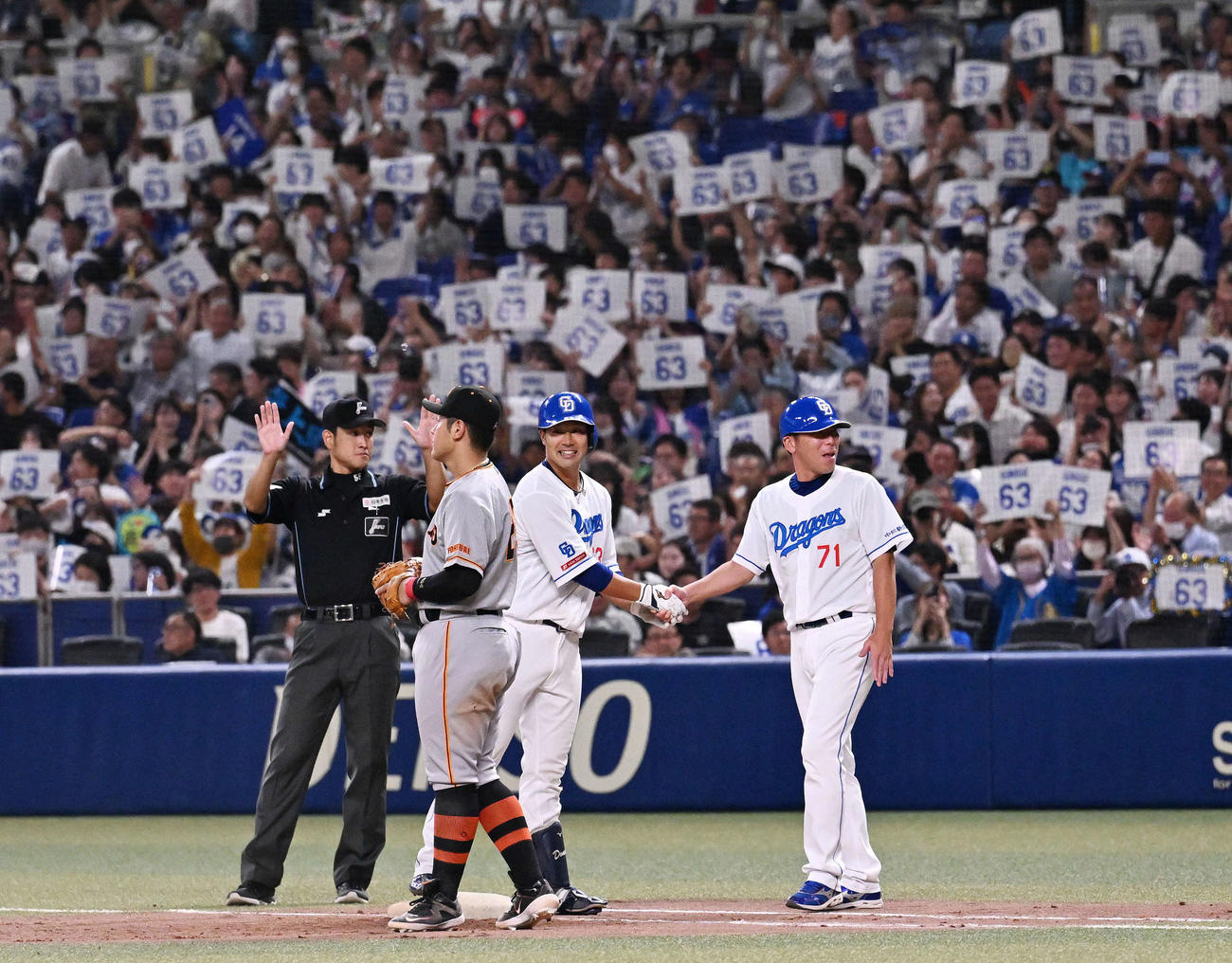 中日対巨人　8回裏中日無死一塁、左前打を放った堂上（左から2人目）は荒木コーチと握手を交わす。一塁手岡本和（撮影・滝沢徹郎）