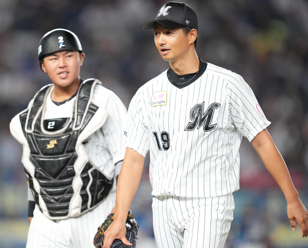 ロッテ対西武　3回表を終え、松川（左）と話しながらベンチへ戻るロッテ唐川（撮影・鈴木みどり）