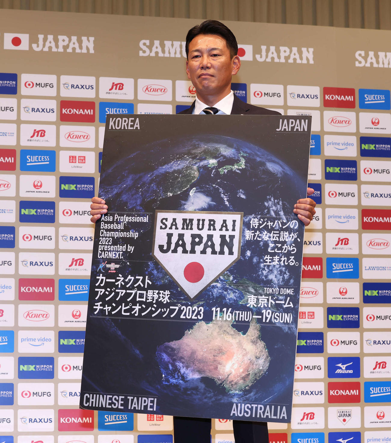 初陣となるアジアプロ野球チャンピオンシップの大会ボードを手にする侍ジャパンの井端監督（撮影・丹羽敏通）