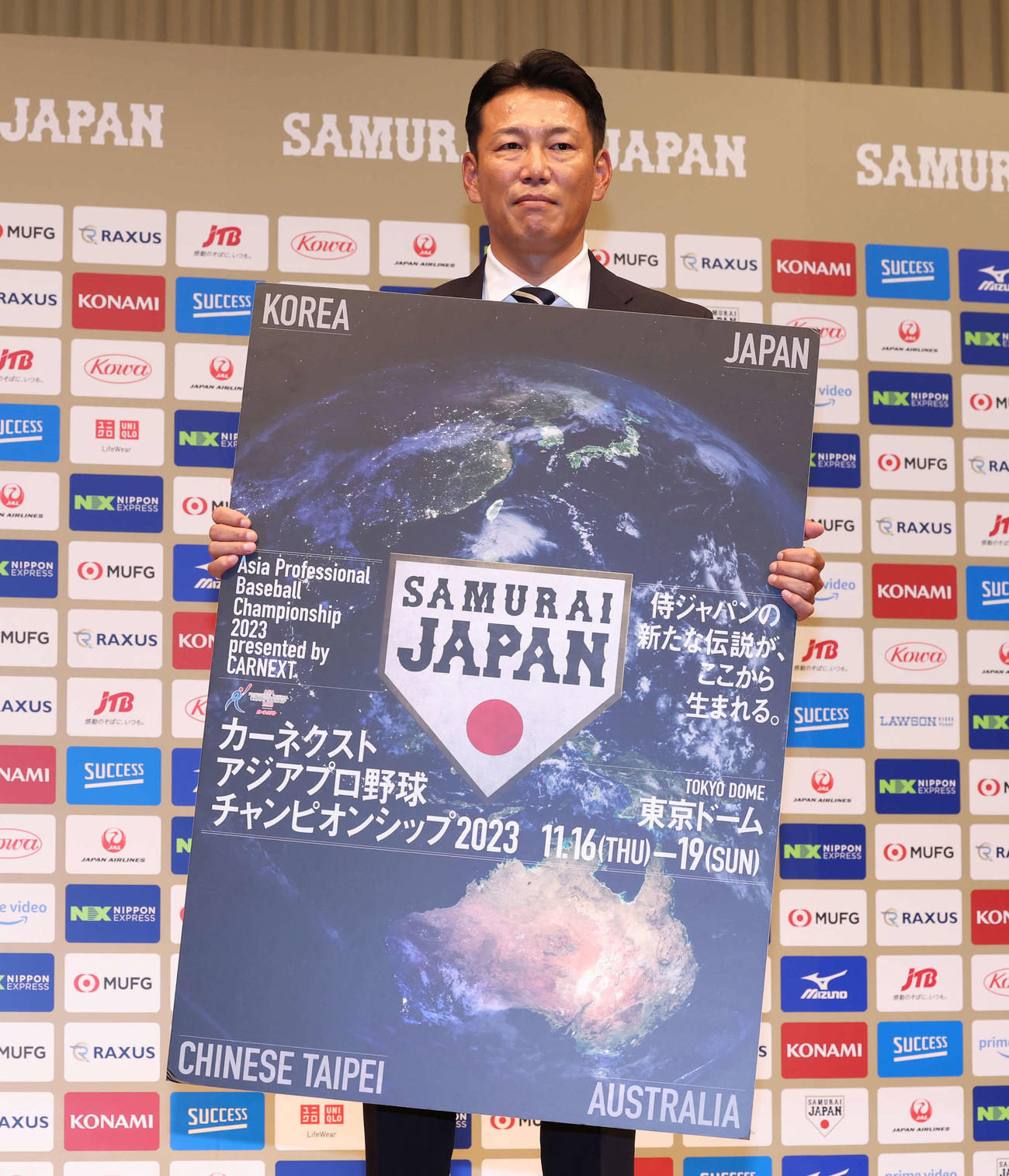 初陣となるアジアプロ野球チャンピオンシップの大会ボードを手にする侍ジャパンの井端監督（撮影・丹羽敏通）