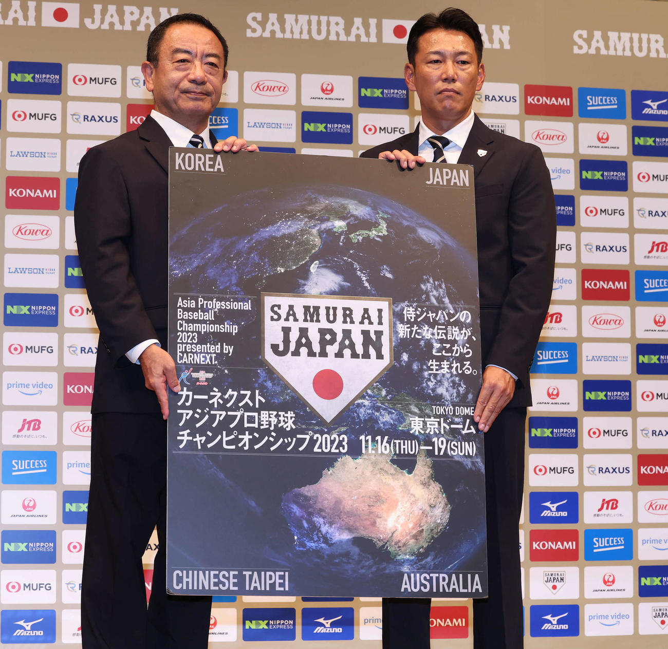 初陣となるアジアプロ野球チャンピオンシップの大会ボードを手に写真に納まる侍ジャパン強化委員会の井原委員長（左）と井端新監督（撮影・丹羽敏通）