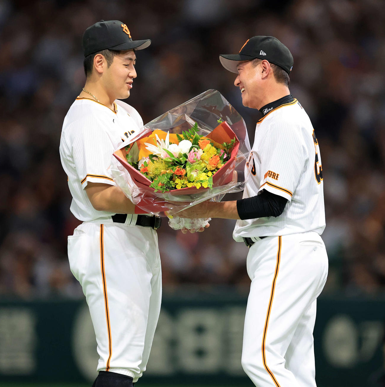 最終戦セレモニーで辞任を表明した巨人原監督（右）は岡本和から花束を受け取る（撮影・浅見桂子）