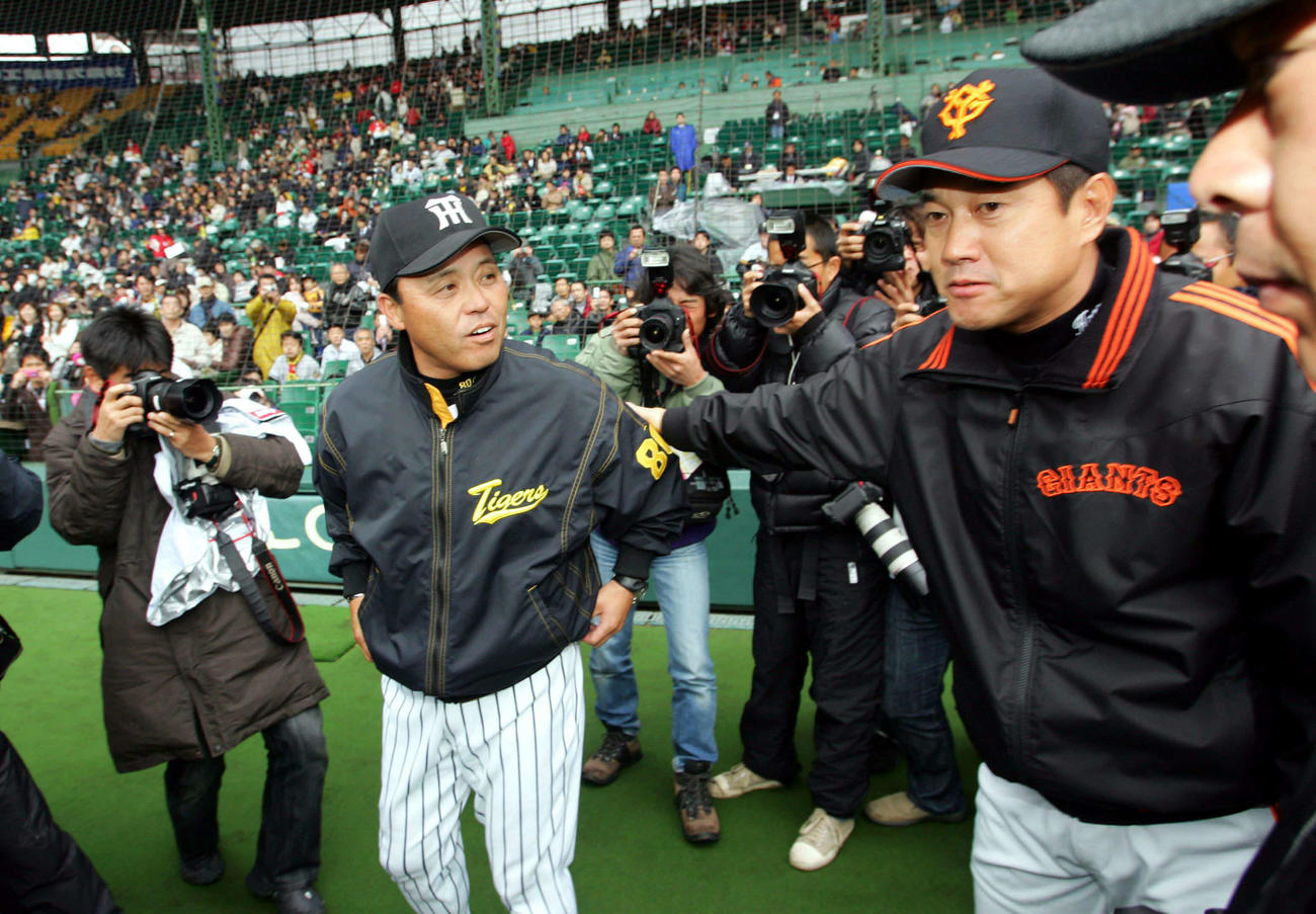 2006年3月、メンバー表交換で挨拶する阪神・岡田彰布監督（左）と巨人・原辰徳監督