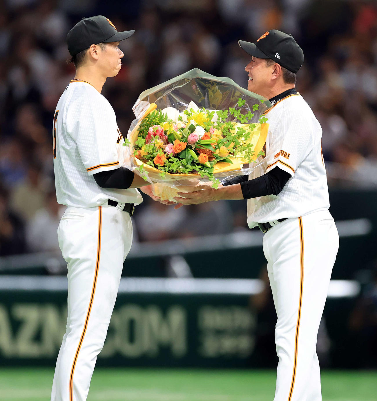 最終戦セレモニーで辞任を表明した巨人原監督（右）は、涙ぐむ坂本から花束を受け取る（撮影・浅見桂子）