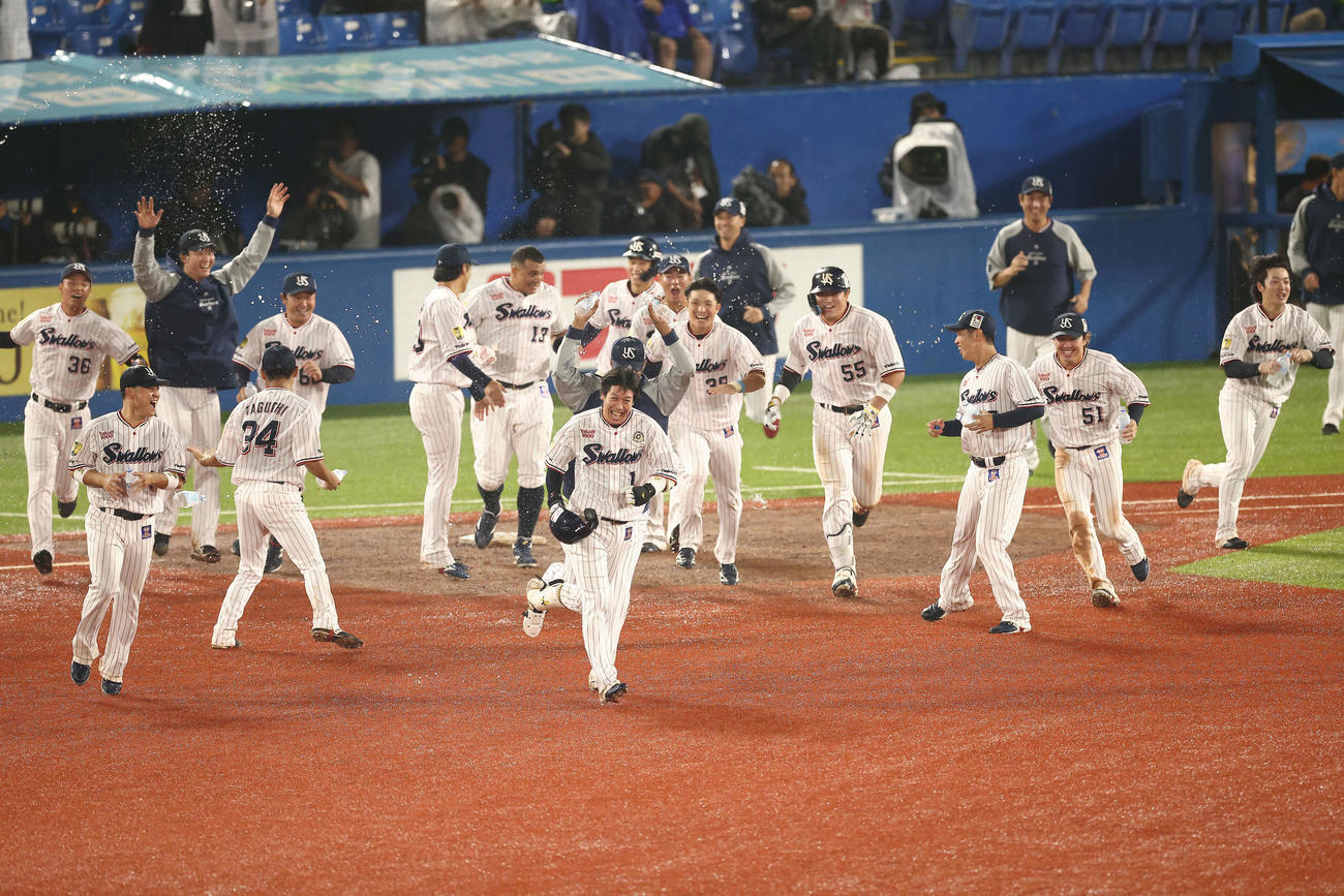 ヤクルト対阪神　9回裏ヤクルト1死一、三塁、中犠飛でサヨナラ勝利し、チームメートに祝福される山田（中央）（撮影・河田真司）