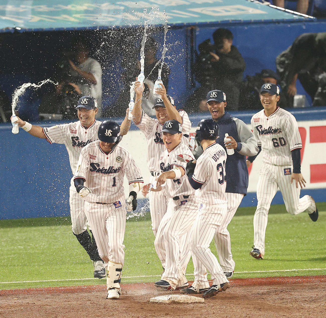 ヤクルト対阪神　9回裏ヤクルト1死一、三塁、中犠飛を放ちサヨナラ勝利を決め、チームメートに祝福される山田（手前左）（撮影・河田真司）