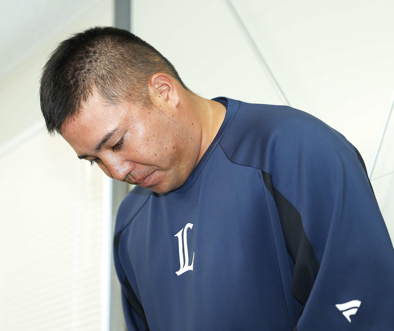 報道陣の前で深々と頭を下げる西武山川（撮影・河田真司）