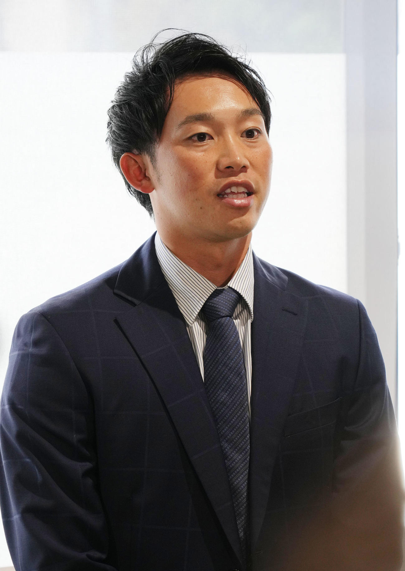 球団事務所に訪れ取材に応じる岡野（撮影・森本幸一）