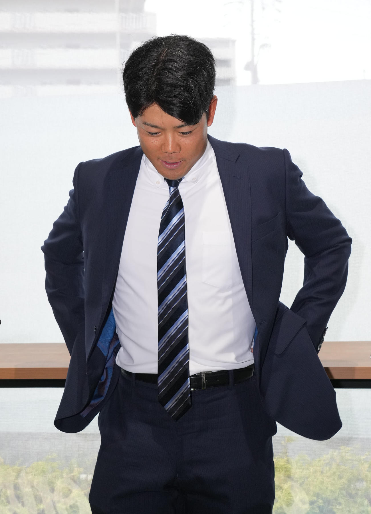 球団事務所に訪れ取材に応じうつむく松田（撮影・森本幸一）