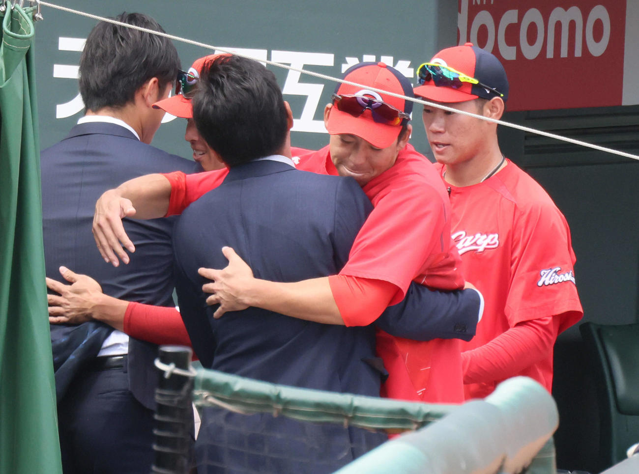 練習の合間にベンチ前で、戦力外となった三好をハグする野間（右から2人目）。左は戦力外の岡田。右は坂倉（撮影・加藤孝規）