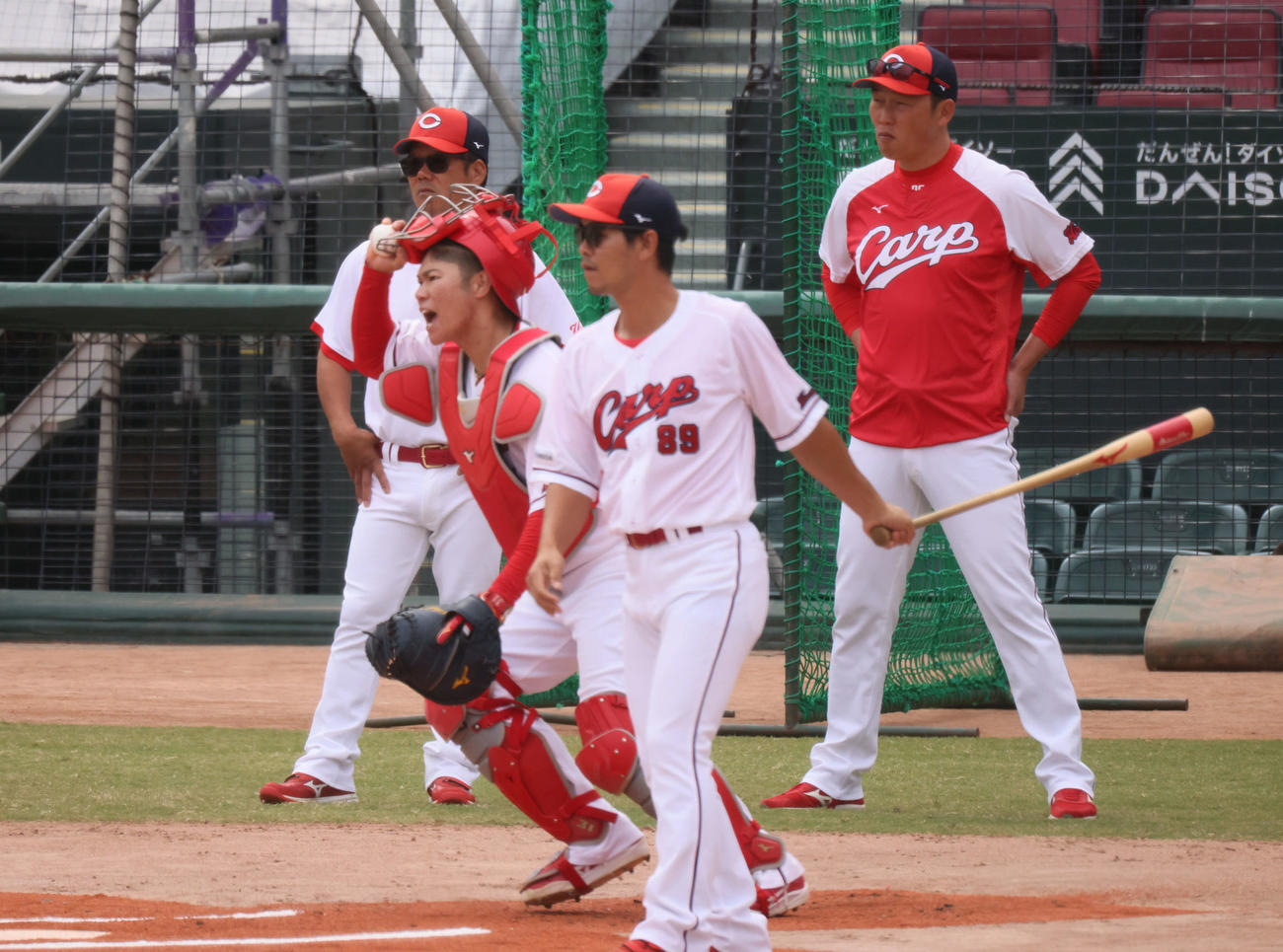 広島全体練習　投内連係練習をする坂倉。後方左は藤井ヘッドコーチ。後方右は新井監督。ノッカーは小窪コーチ（撮影・加藤孝規）