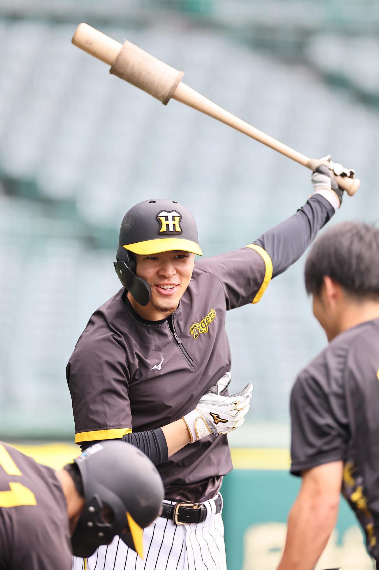 笑顔をみせながらバットを振る佐藤輝（2023年10月3日撮影）