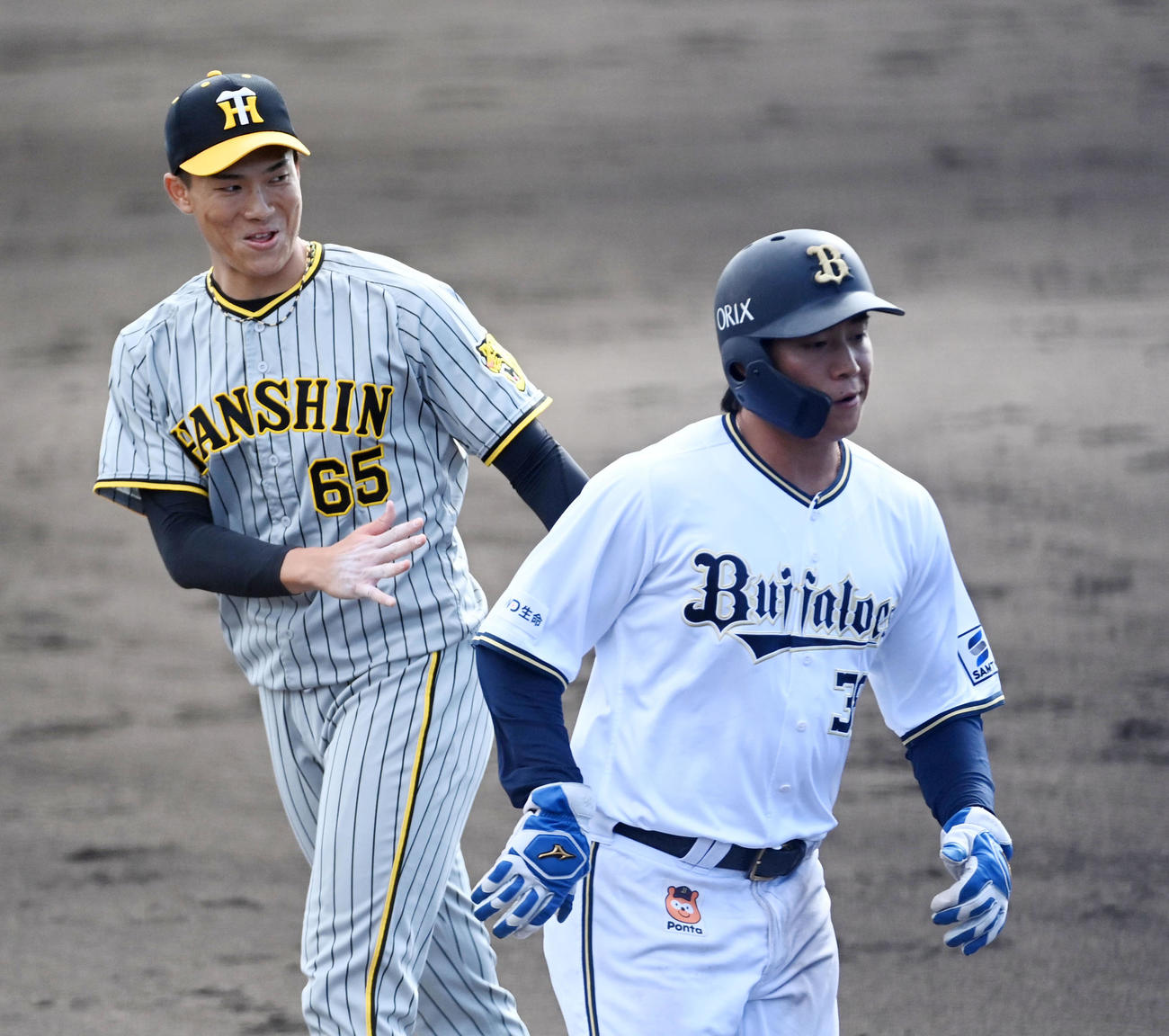 オリックス対阪神　阪神2番手の湯浅（左）はオリックス打線を1回無失点に抑え笑顔でベンチに戻る（撮影・前岡正明）