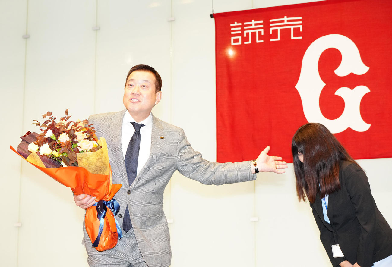 監督交代会見後、球団職員の女性から花束を受け取った巨人原監督（左）（撮影・江口和貴）