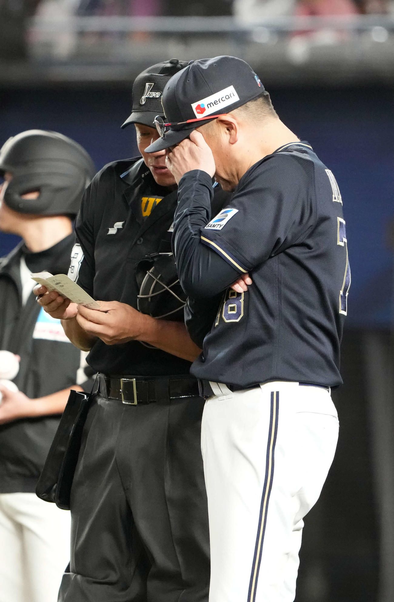 ロッテ対オリックス　手で顔を覆いながら球審に選手交代を告げるオリックス中嶋監督（撮影・小沢裕）