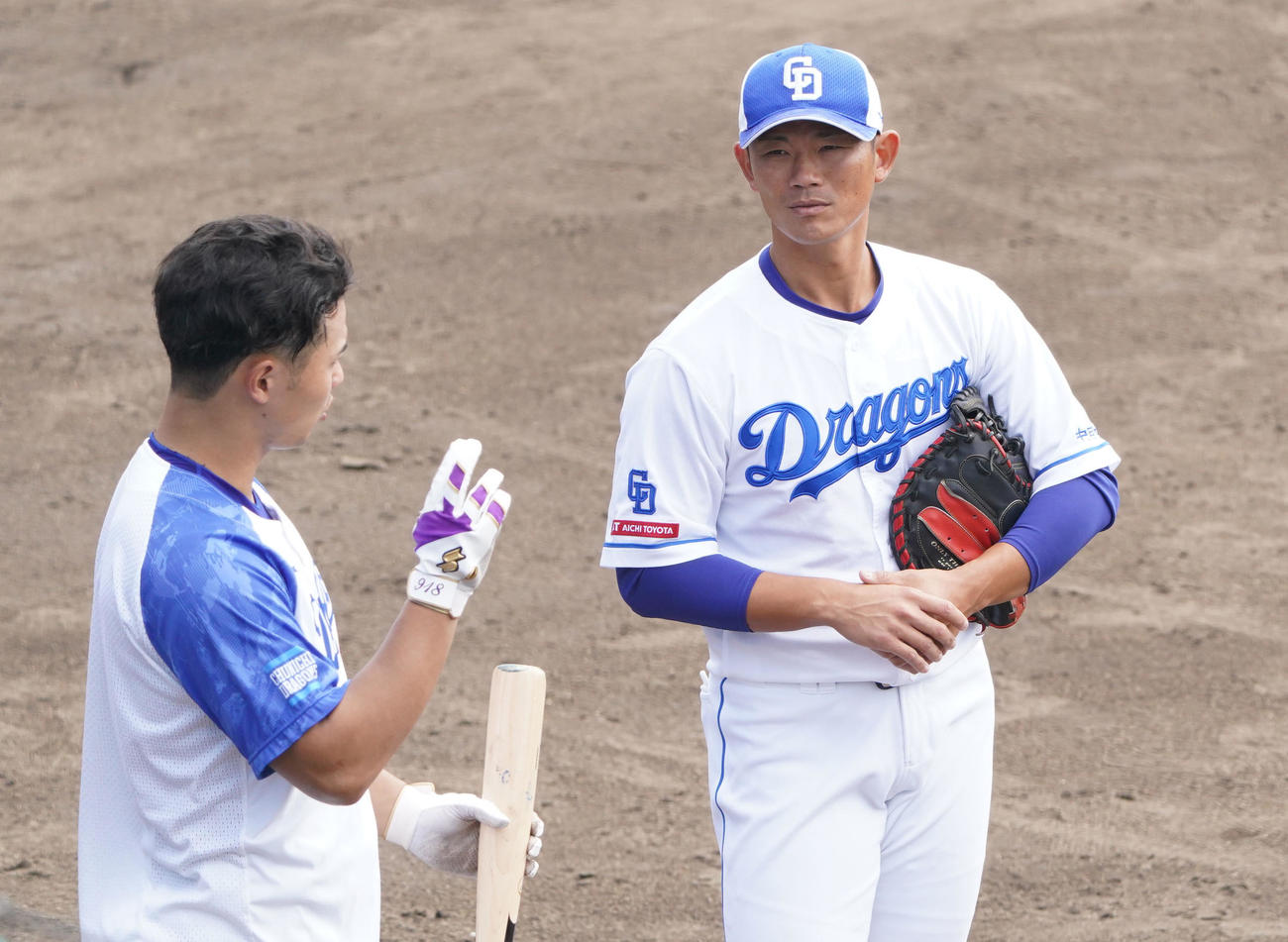 石橋康と言葉を交わす大野奨バッテリーコーチ（右）（撮影・森本幸一）