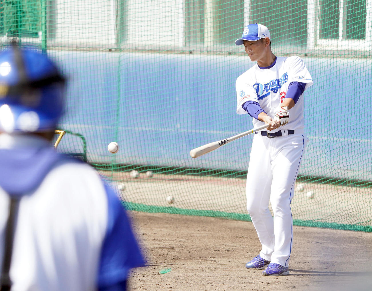 捕手陣にノックをする大野奨バッテリーコーチ（撮影・森本幸一）
