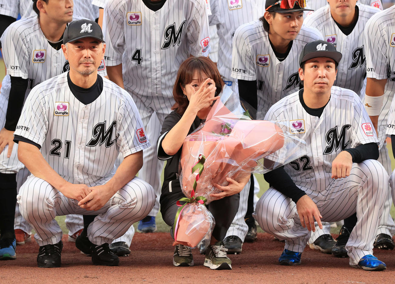 ロッテ対オリックス　今季限りで場内アナウンスから卒業する谷保恵美さん（中央）は、ロッテ吉井監督（左）らとの記念撮影で涙をぬぐう（撮影・浅見桂子）