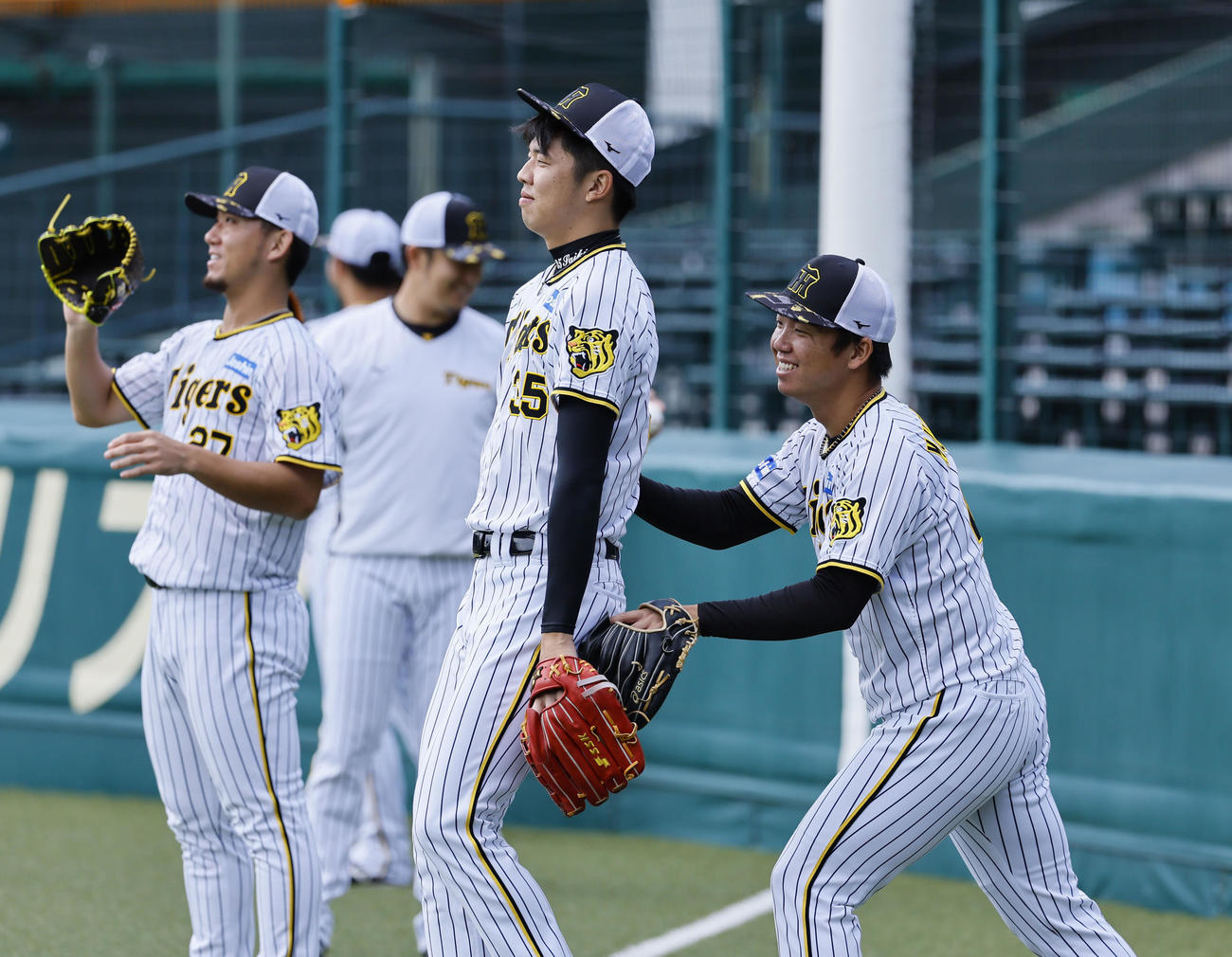 キャッチボールの前に、じゃれ合う阪神村上（右端）と才木（撮影・藤尾明華）