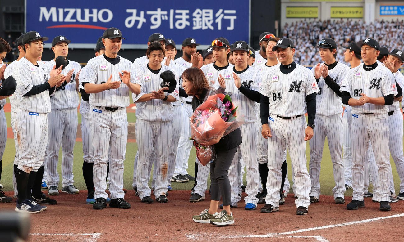 ロッテ対オリックス　今季限りで場内アナウンスから卒業する谷保恵美さん（中央）は、吉井監督（左）らロッテの選手から拍手で送られる（撮影・浅見桂子）