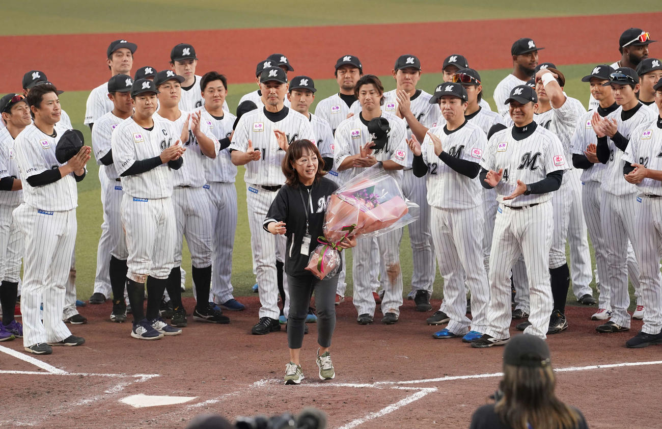 ロッテ対オリックス　今季限りでの引退を発表したZOZOマリンスタジアム場内アナウンス担当の谷保さん（中央）は記念撮影を終えナインからねぎらいの拍手を受ける（撮影・小沢裕）
