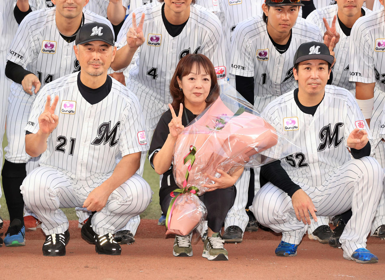 ロッテ対オリックス　今季限りで場内アナウンスから卒業する谷保恵美さん（中央）は、ロッテ吉井監督（左）らとの記念撮影でVサイン（撮影・浅見桂子）