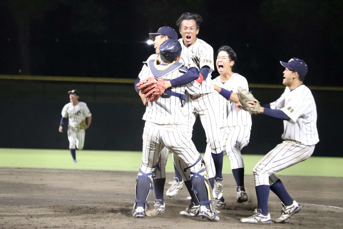上武大対白鴎大　9回表、最後の打者を空振り三振に抑え、2番手の木口永翔投手とマウンドで抱き合う上武大・進藤（撮影・保坂淑子）
