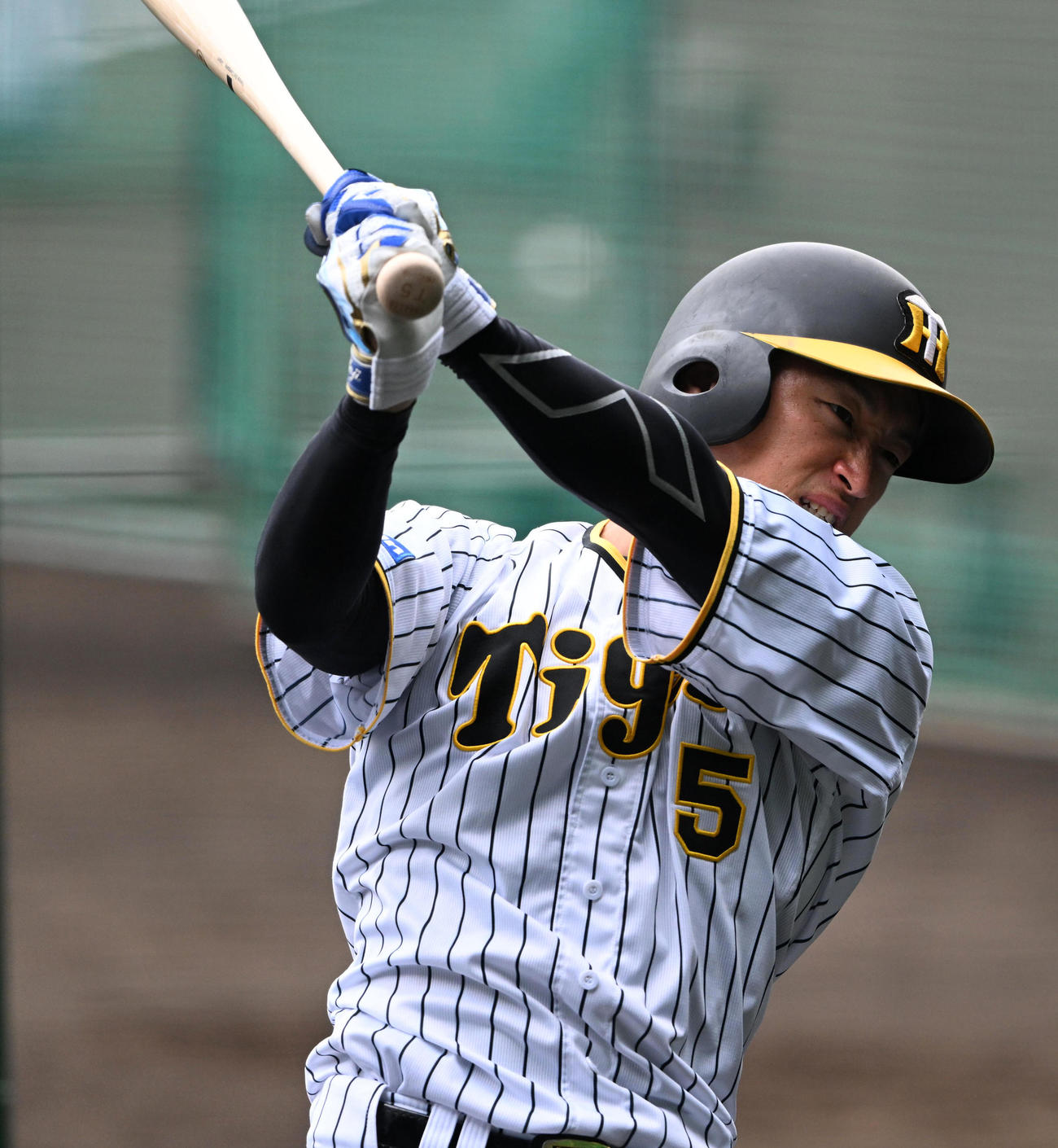 気合いの表情でティー打撃を行う近本（撮影・前岡正明）