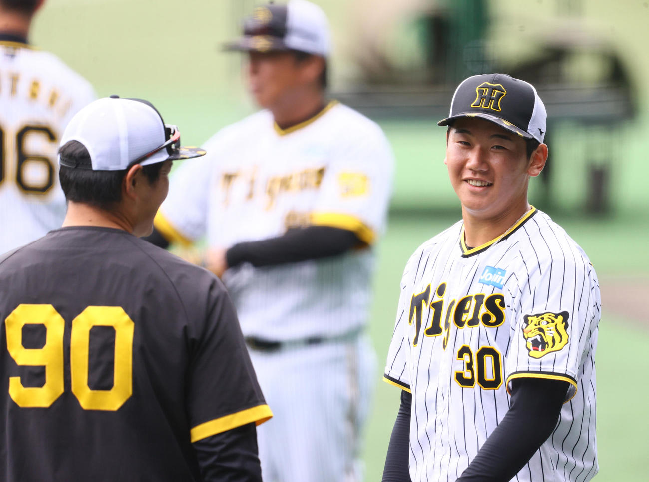 実践形式の登板を終えた阪神門別（右）は笑顔で久保田投手コーチの話を聞く（撮影・上山淳一）