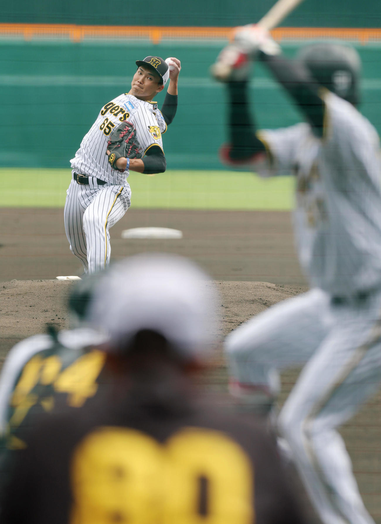 阪神岡田監督（手前）が見守る中、シート打撃に登板する湯浅。打者中野（撮影・前田充）