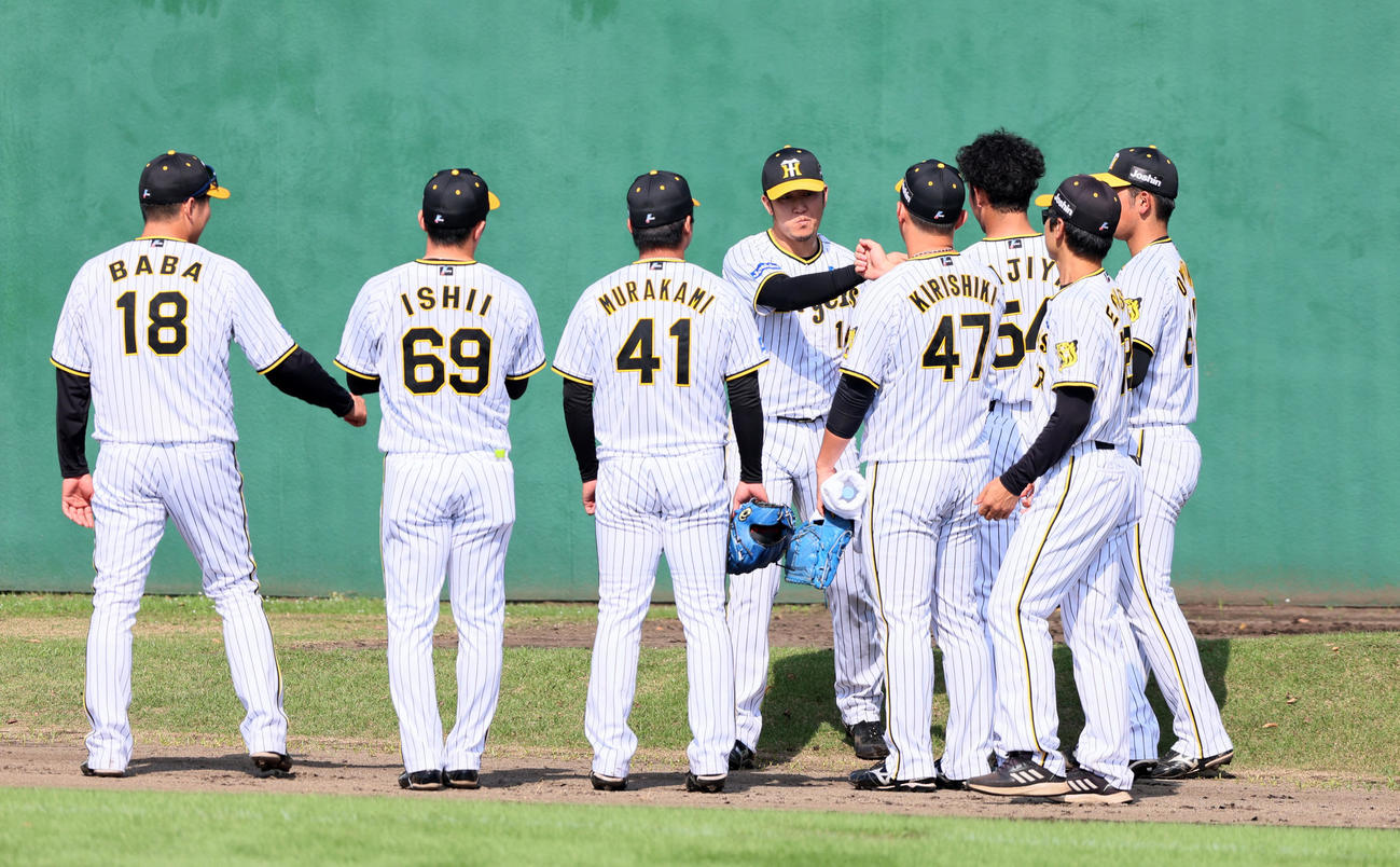 阪神対ヤクルト　6回表、ブルペンでナインとタッチしてマウンドへ向かう岩貞（撮影・加藤哉）