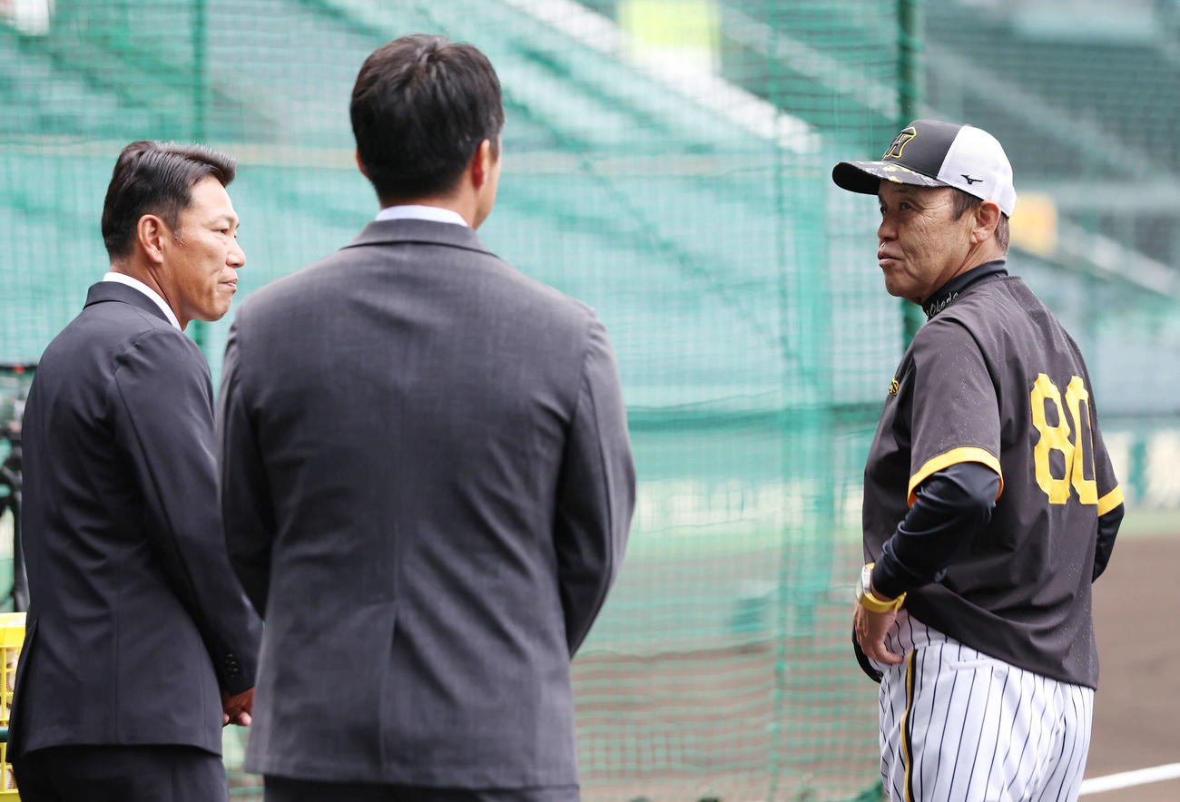侍ジャパン井端監督（左）からあいさつを受けた阪神岡田監督（右）。中央は吉見氏（撮影・前田充）