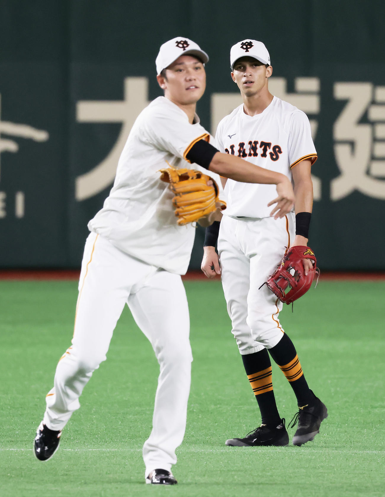 21年9月10日、遊撃の守備位置でノックを受ける巨人坂本（左）を見つめるデラクルーズ