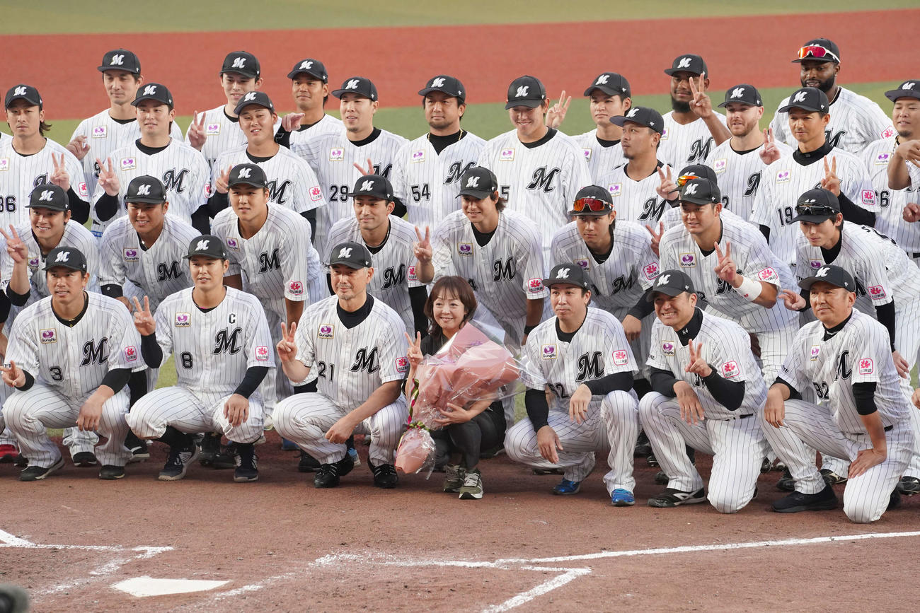 今季限りでの引退を発表したZOZOマリンスタジアム場内アナウンス担当の谷保さん（中央）はロッテナインらとの記念撮影で笑顔を見せる（2023年10月7日撮影）