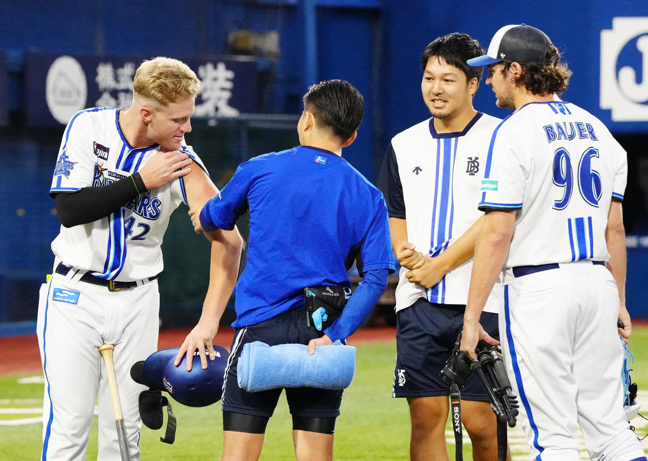 練習後、DeNAバウアー（右端）に死球を受けた左腕を見せるアンバギー（左端）（撮影・江口和貴）