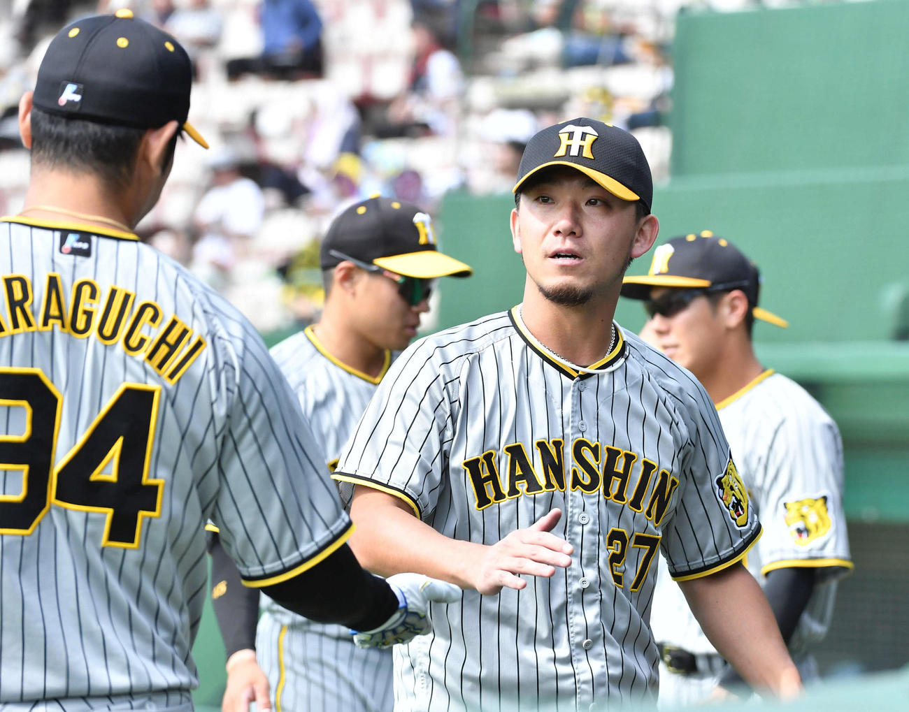 楽天対阪神　5回を投げ終え、原口（左）らナインとタッチを交わしながらベンチへ戻る伊藤将（撮影・岩下翔太）