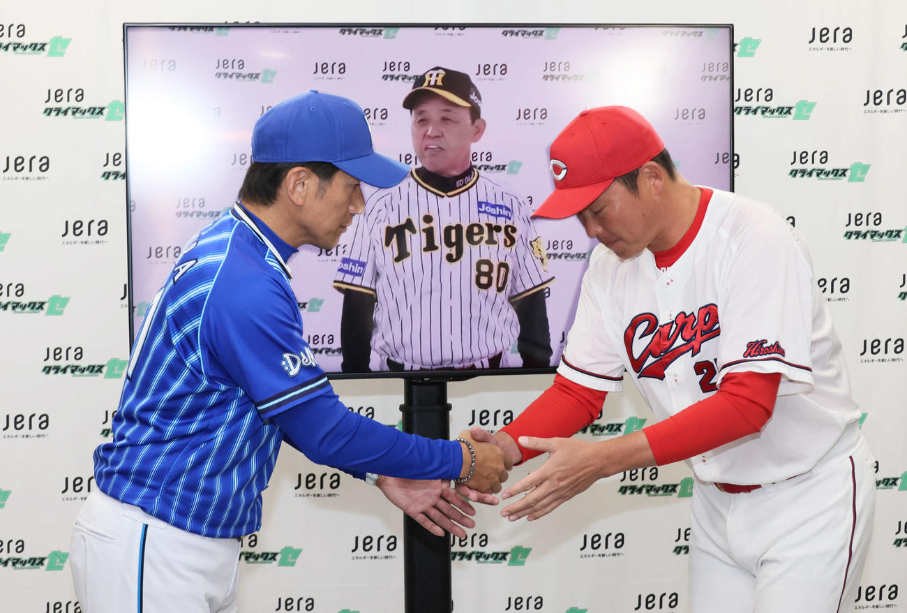 セCSファーストS前日会見　会見後、モニター越しの阪神岡田彰布監督の前で、握手するDeNA三浦大輔監督（左）と広島新井貴浩監督（撮影・加藤孝規）