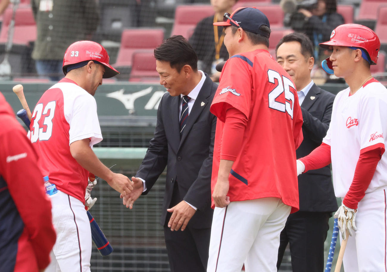 セCSファーストS第1戦　試合前練習中、侍ジャパンの井端監督（左から2人目）と握手する菊池（左）。左から3人目は新井監督。右は西川（撮影・加藤孝規）