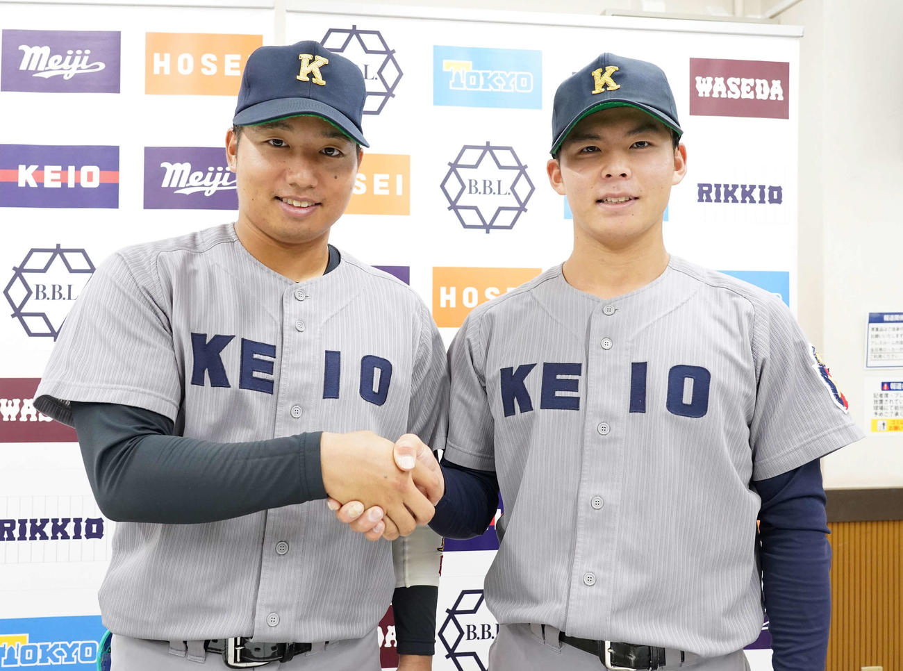 明大対慶大　明大に先勝し互いに握手する先制打の慶大・栗林泰（左）と完投勝利を飾った外丸（撮影・小沢裕）