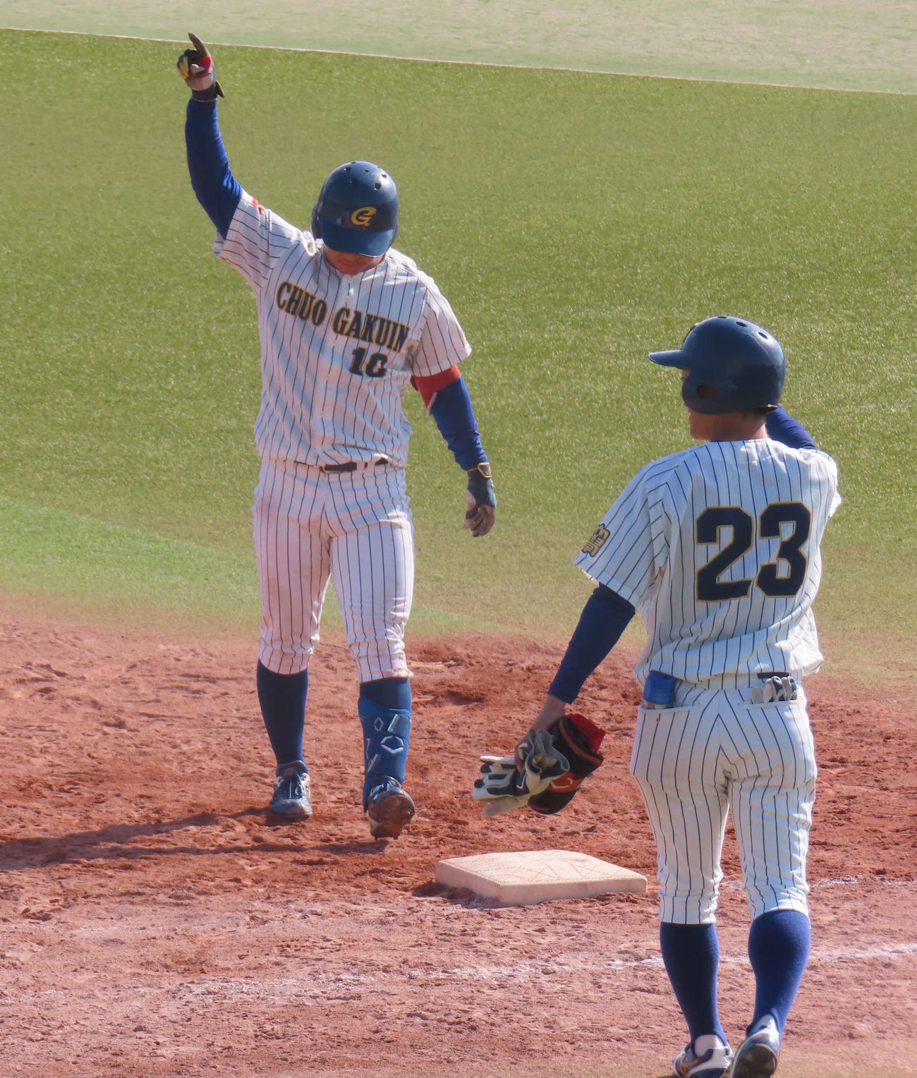 中央学院大対千葉経大　延長10回タイブレークで2死二塁から中前打を放ち、右手を挙げて喜ぶ中央学院大・下山