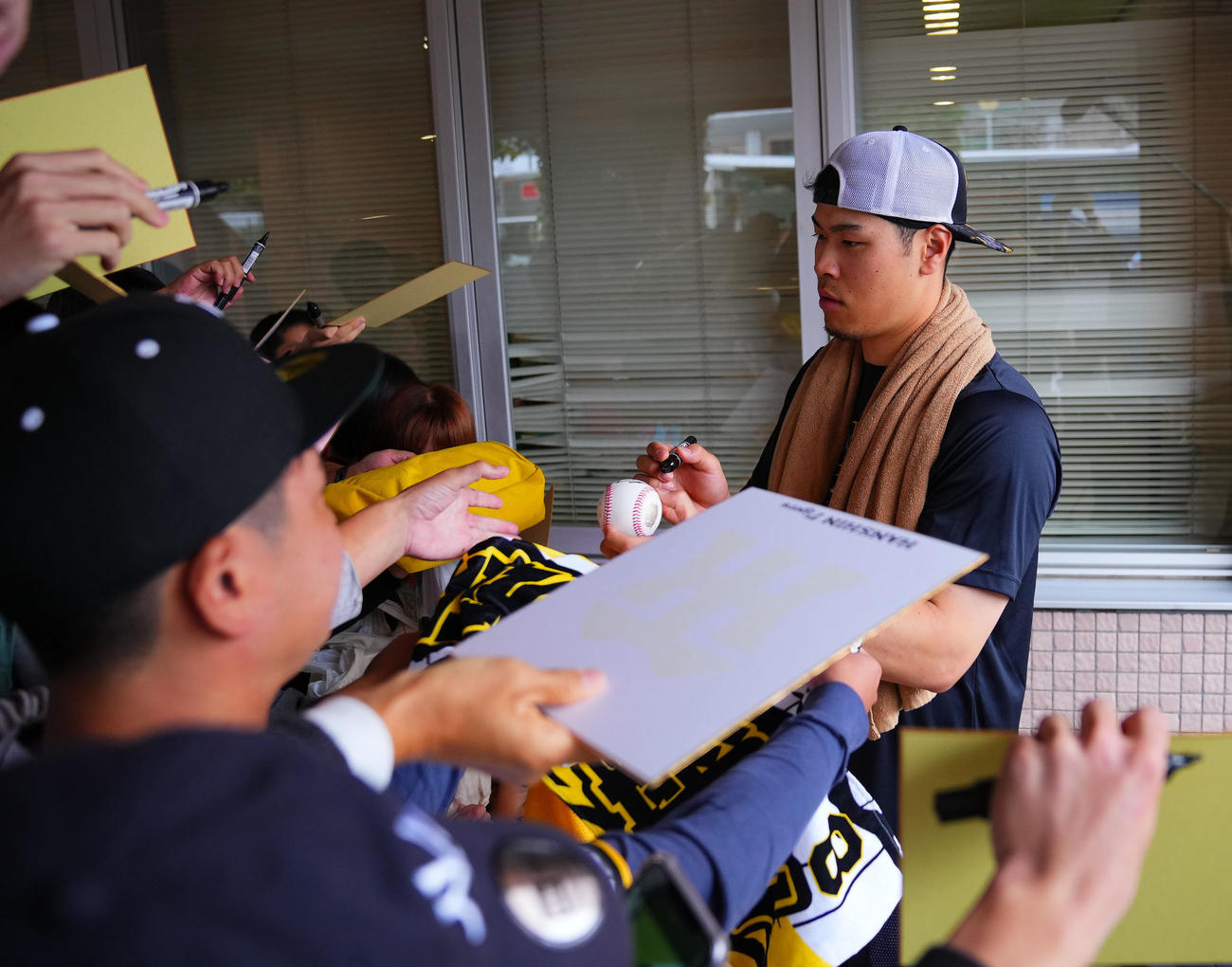フェニックスリーグ西武対阪神　ファンにサインする阪神佐藤輝（撮影・藤尾明華）