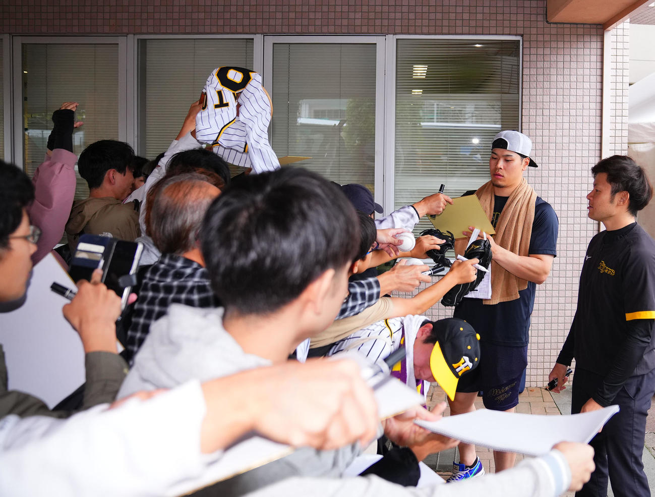 フェニックスリーグ西武対阪神　ファンにサインする阪神佐藤輝（撮影・藤尾明華）