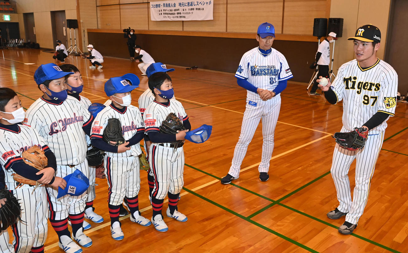 昨年12月、プロ野球・奈良県人会の野球教室でアドバイスする阪神小野寺（右）とDeNA三浦監督