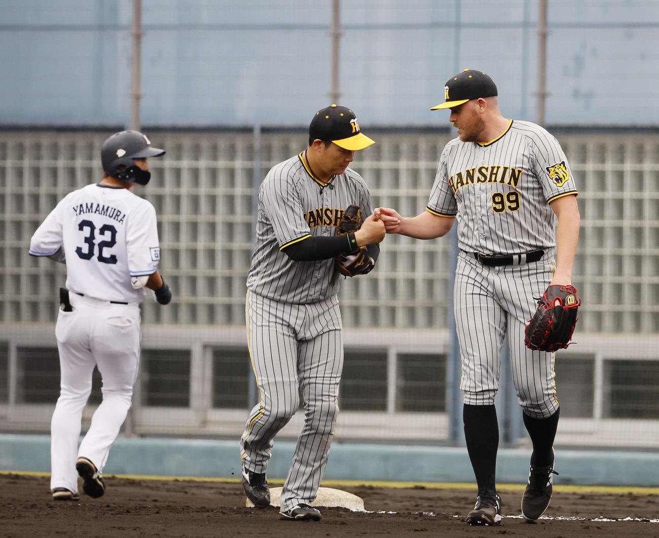 フェニックスリーグ西武対阪神　6回を抑え、大山（中央）とグータッチを交わす阪神ビーズリー（右）（撮影・藤尾明華）
